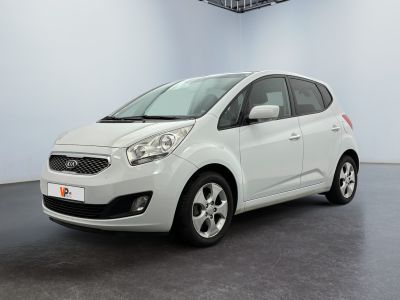 the small white car is parked in a large room
