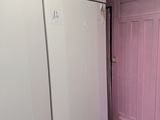 un réfrigérateur blanc et une porte rose dans une pièce