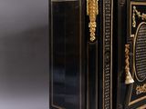 an antique black and gold painted cabinet with a marble top