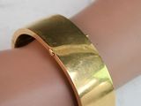 gold plated cuff bracelet on a woman ' s arm