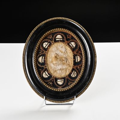 une assiette noire et dorée sur laquelle est représenté un visage