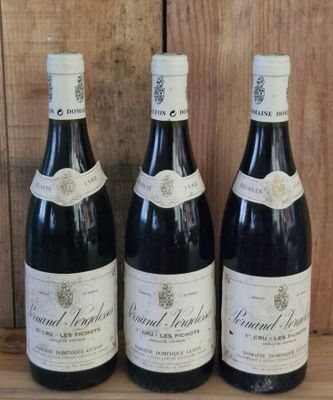 three bottles of wine are lined up on a wooden shelf