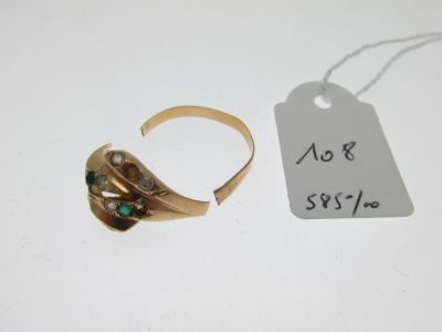 une photo montrant une bague en or et une étiquette posées sur une table blanche
