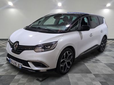 la voiture blanche est garée sur un sol en damier dans le garage