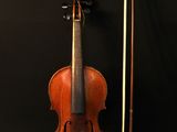an old violin with a bow and bow rest on a black background