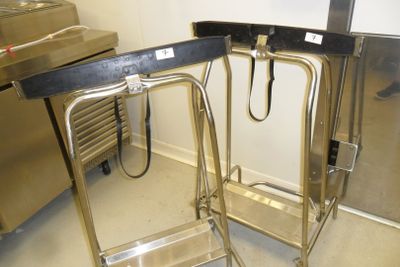 a metal cart with a metal handle in a kitchen
