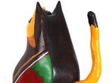 brightly colored cat figurine sitting on a white surface with a white background