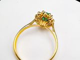 an image of a gold ring with a green stone in the center