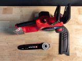 a red cordless nailer and a wrench on a table