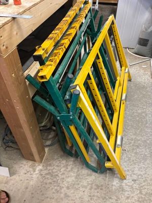 a pile of yellow and green ladders sitting on the floor