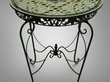 a green table with a metal base and a circular top