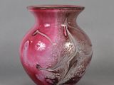 a pink glass vase with a bird design on it