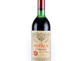 a bottle of red wine sitting on top of a white table