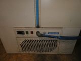 une machine blanche à laquelle est raccordé un tuyau bleu