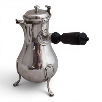 une cafetière en argent avec une poignée noire sur fond blanc