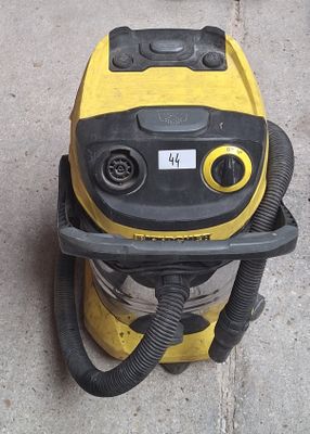 un aspirateur jaune et noir posé sur le trottoir
