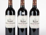 trois bouteilles de vin rouge posées l'une à côté de l'autre sur une surface blanche