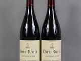 two bottles of wine sitting on top of a table next to each other