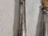 deux cuillères et un couteau sur une table