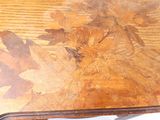a close up of a wooden table with leaves on it