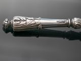 an image of a silver pen sitting on top of a black surface