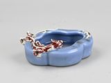 a blue bowl with a dragon on it on a white surface