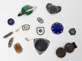 an assortment of assorted brooches and jewelry on a white surface