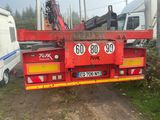 un camion rouge équipé d'une grue à l'arrière