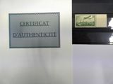 une affiche accrochée au mur sur laquelle on peut lire « certificat d'authenticité »