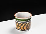 a small cup sitting on top of a white table