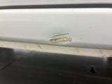 a small piece of metal on the side of a white car