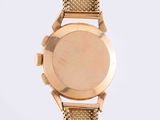 a close up of a gold watch on a white background