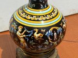 un vase noir et doré posé sur une table en bois