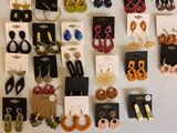 de nombreuses paires de boucles d'oreilles accrochées ensemble au mur