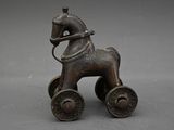 bronze figurine of a horse pulling a cart with a man on it