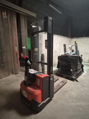 un chariot élévateur à fourche dans un bâtiment dont la porte est verte