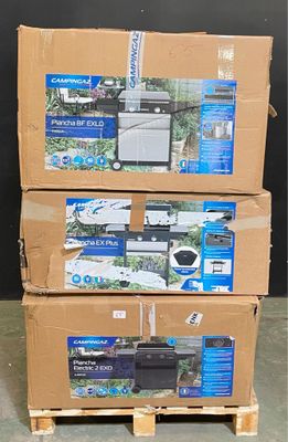 Trois cartons contenant du matériel électronique sont empilés sur des palettes dans un entrepôt