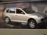 a silver toy car in a clear box on a table