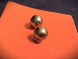 pair of silver ball stud earrings on an orange cloth