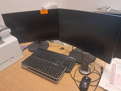 a computer desk with two monitors and a keyboard on it