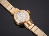 gros plan d'une montre-bracelet en or sur une surface noire