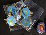 a bag of badges and a pin sitting on a table