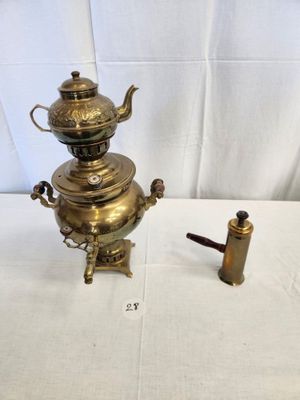 a small brass teapot and a small brass teapot on a table