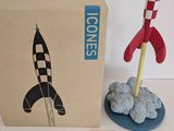 a toy rocket sitting next to a cardboard box on a table