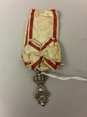 a close up of a red and white ribbon with a cross on it