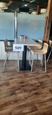 une table et des chaises dans une pièce où est affichée une étiquette de prix