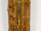 a gold colored object on a white surface