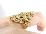 a woman ' s hand holding a gold ring with diamonds on it