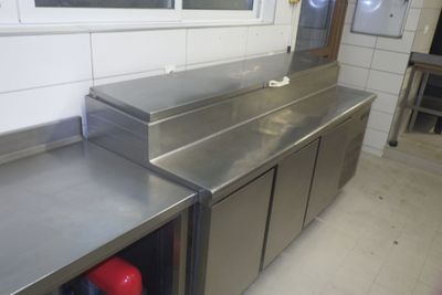 plans de travail en acier inoxydable dans une cuisine professionnelle dotée d'une fenêtre