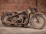 a old motorcycle that is sitting in the dirt